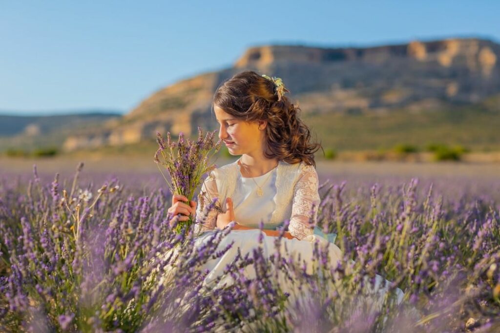 Niña oliendo unas flores de lavanda